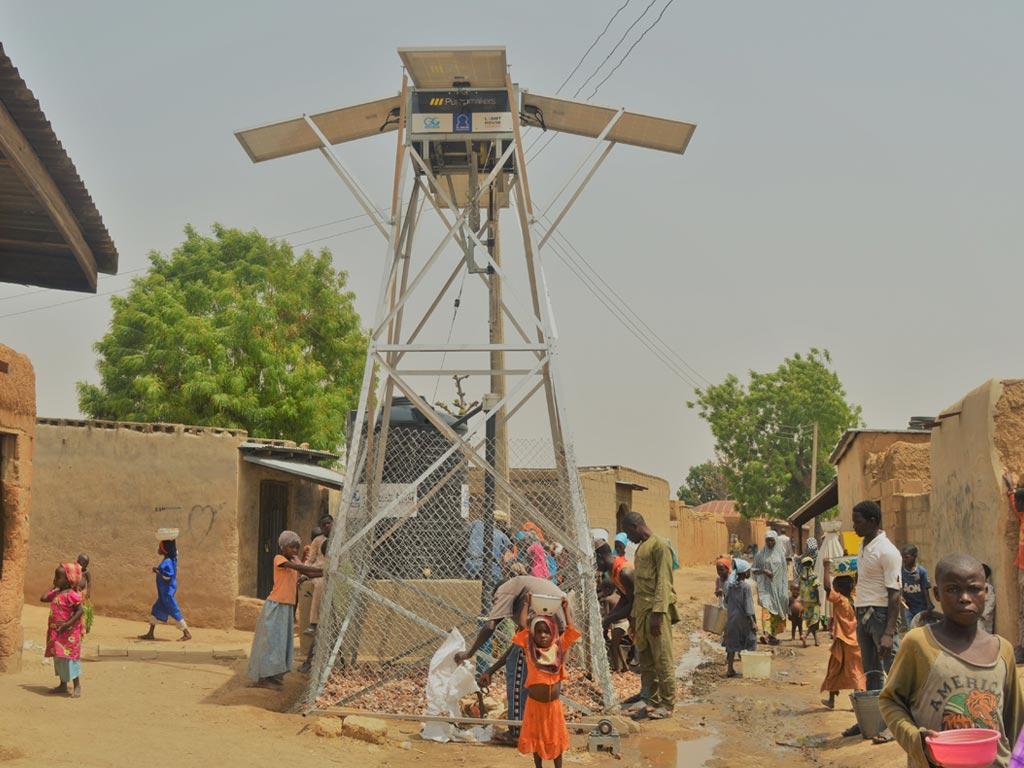 african kid carrying water, solar pump water well